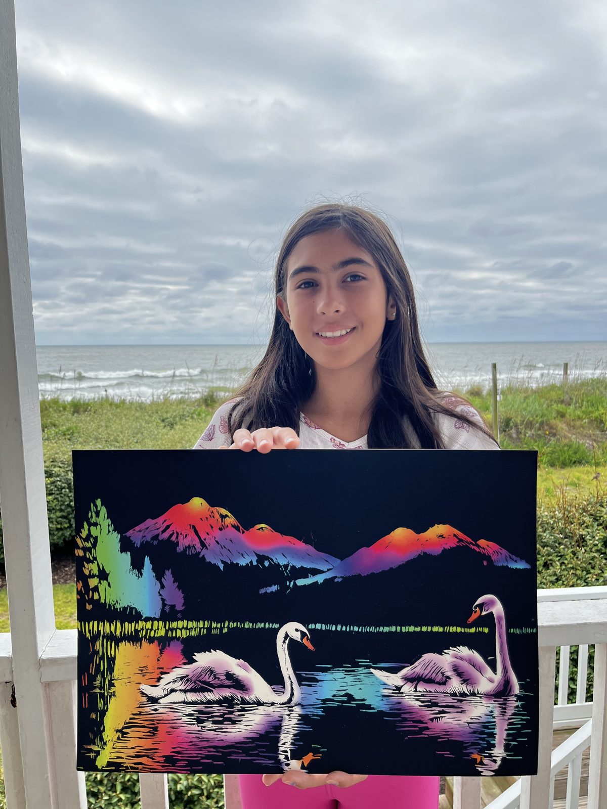 Customer with a finished swans canvas at the beach